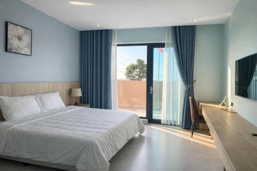 a bedroom with a bed and a sliding glass door at Balat Resort in Tập Thiện