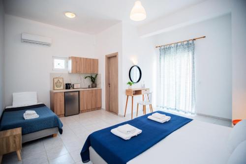 a large room with two beds and a kitchen at Fardini Resorts in Kavos