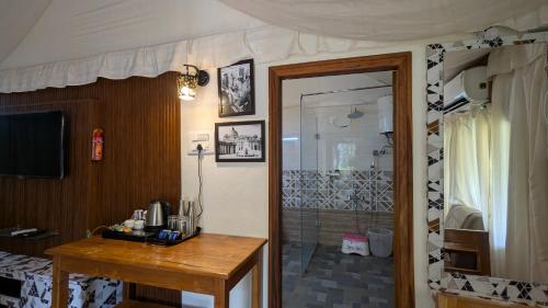 a bathroom with a shower and a wooden table with a sink at Advaya Luxury Resort, Sakleshpur in Sakleshpur