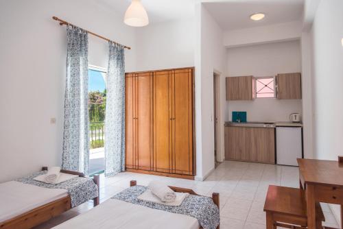 a bedroom with two beds and a kitchen at Fardini Seaside Hotel in Kavos