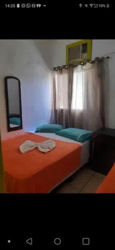 a bedroom with two beds with orange sheets and a window at Aconchego de Olinda in Olinda