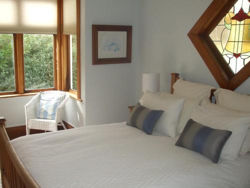 a bedroom with a white bed with pillows and a window at One Panama in Martinborough