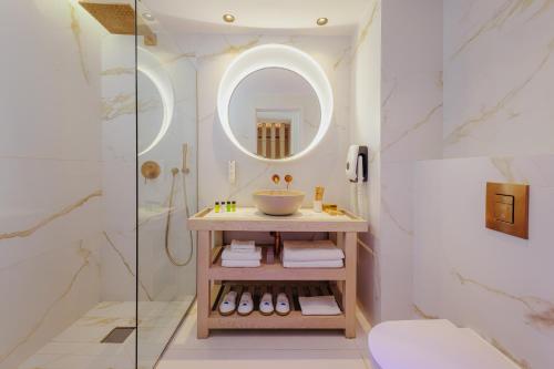 a bathroom with a sink and a mirror at NissiBlu Beach Resort in Ayia Napa