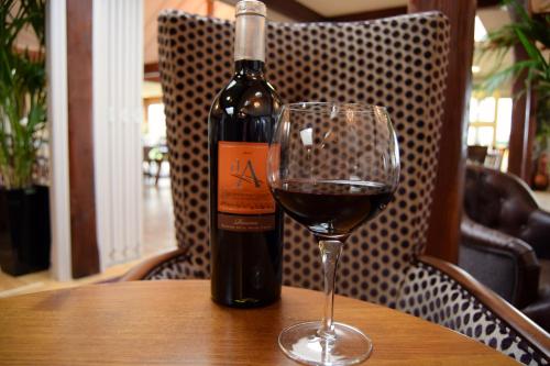a bottle of wine sitting on a table with a glass at Briarfields Hotel in Titchwell