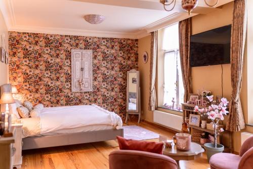 a bedroom with a bed and a floral wall at Bed & Boterham Carpediem in Hamont