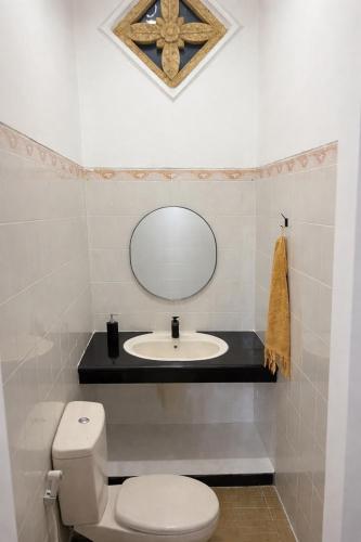 a bathroom with a sink and a toilet and a mirror at Villa Stella Garden in Senggigi