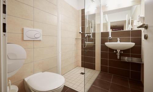 a bathroom with a toilet and a sink at Grafenberg Resort by Alpeffect Hotels in Wagrain