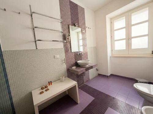a bathroom with a sink and a toilet at Ortigia Mastrarua rooms in Syracuse
