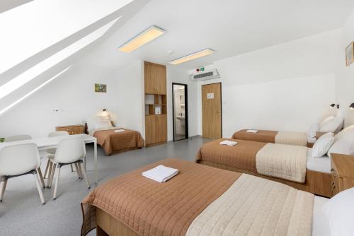 a hotel room with two beds and a table and chairs at Nyíltvízi Edzőközpont in Dunakeszi
