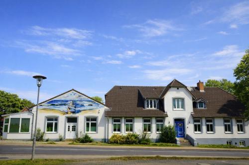 a white house with a painting on the side of it at Ostseelandhaus DHH Wendy 1 in Proseken