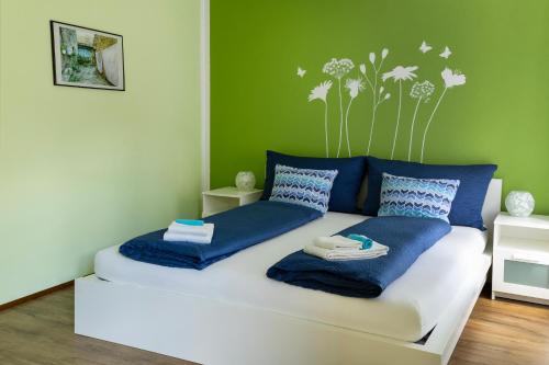 a bedroom with a bed with blue pillows and dandelions at Ca' di Pincia in Astano