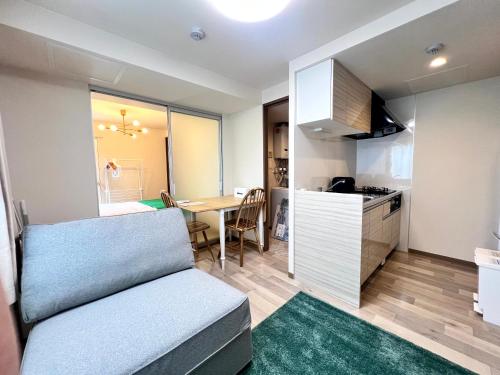 a small apartment with a couch and a kitchen at ホロムア澄川 in Sapporo