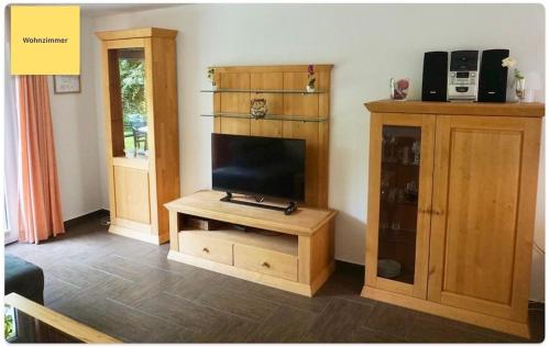 a living room with a tv and a wooden cabinet at Huus Negen in Neuharlingersiel