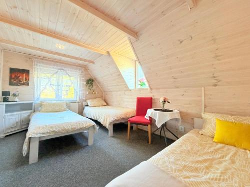 a room with two beds and a table and chairs at Wspaniały Zakątek in Sędziszowa