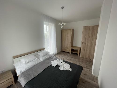 a bedroom with a bed with two towels on it at Paskom Apartmanház in Nyergesújfalu