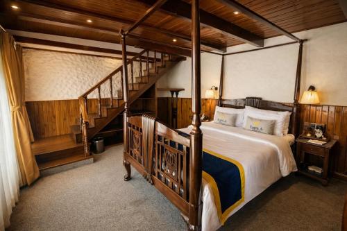 a bedroom with a large bed and a staircase at Cochrane Place By Teesta Hotels in Kurseong