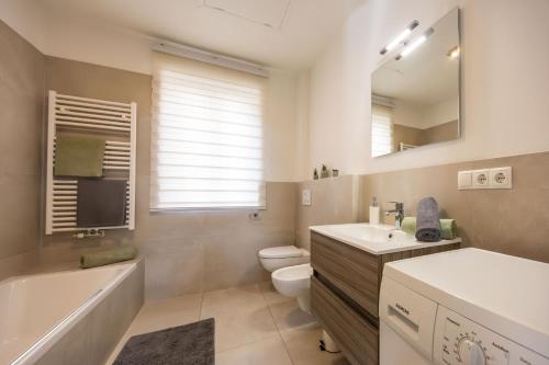 a bathroom with a tub and a toilet and a sink at Ferienhaus Karin in Cortaccia