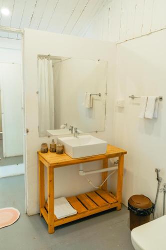 a bathroom with a sink and a mirror at The Pearl Beach Resort in Canacona