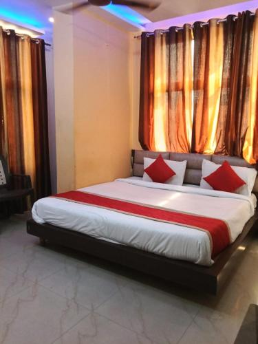 a bedroom with a large bed with red pillows at Hotel Sasa Paradise in Lucknow