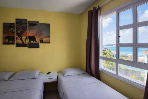 a room with two beds and a window at Yacht Village Flat in Natal