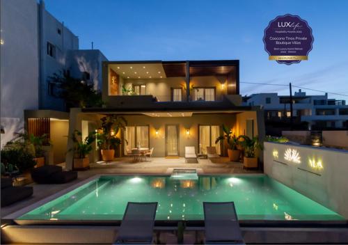 a villa with a swimming pool at night at Coocono Tinos Private Boutique Villas in Tinos