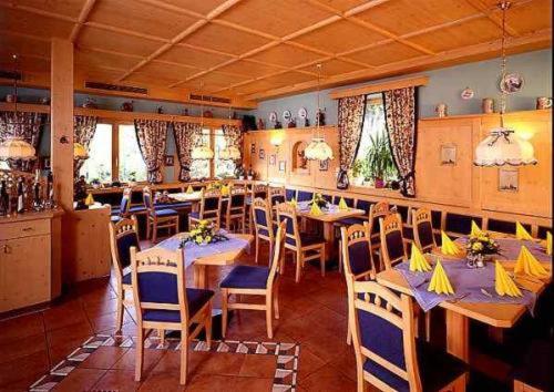 ein Restaurant mit Tischen und Stühlen in einem Zimmer in der Unterkunft Gasthof SONNE in Seehausen am Staffelsee