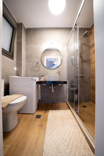 a bathroom with a toilet and a sink and a mirror at Emmari Luxury Suites in Episkopos