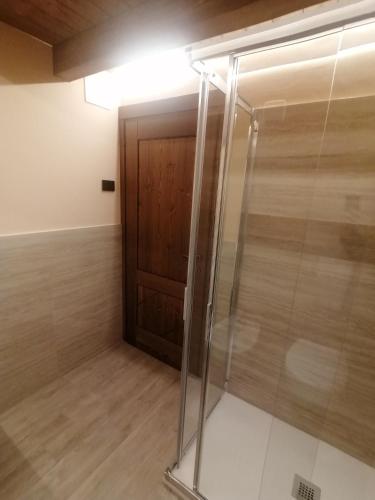 a glass shower in a room with a wooden door at Coudrey 2 in Doues