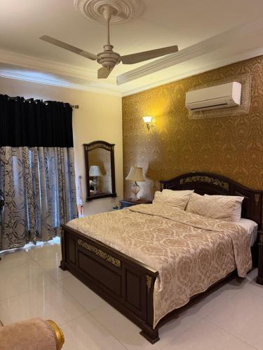 a bedroom with a large bed and a ceiling fan at super nova 1 in Lahore