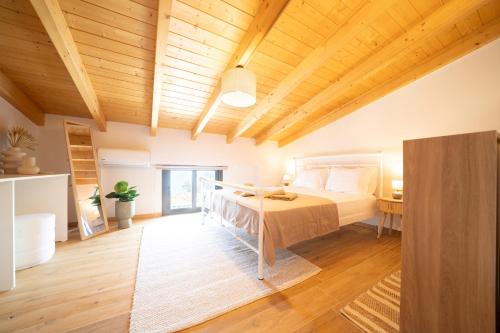 a bedroom with a bed and a wooden ceiling at Emmari Luxury Suites in Episkopos