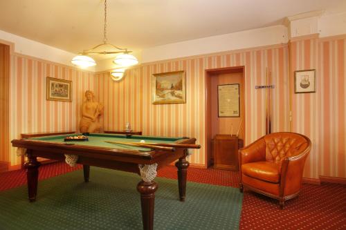 a room with a pool table and a chair at Hotel De Gramont in Pau