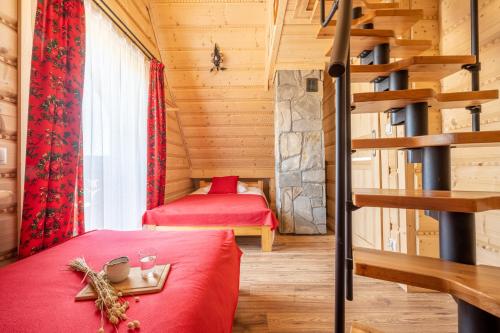 a room with two beds and a staircase in a log cabin at Chochołowskie Domki in Chochołów