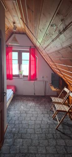 a room with red curtains and a bed and a window at Willa Jordanówka in Czorsztyn