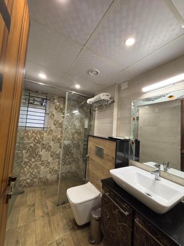 a bathroom with a sink and a toilet and a shower at Hotel White Rock in Bangalore