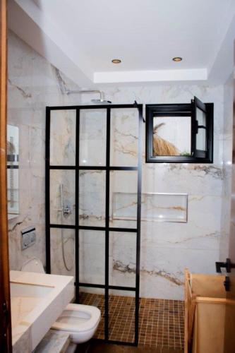 a bathroom with a shower with a toilet and a window at Villa el Kasbah in Midoun