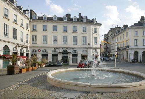 uma fonte no meio de uma rua com edifícios em Hotel De Gramont em Pau