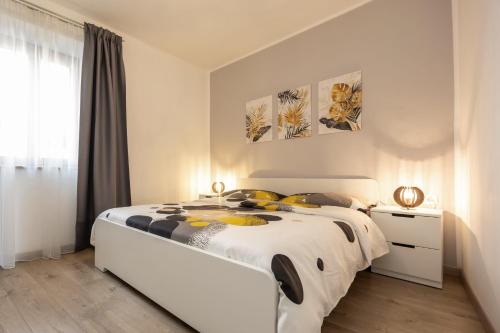 a bedroom with a large white bed with yellow pillows at Ferienhaus Karin in Cortaccia