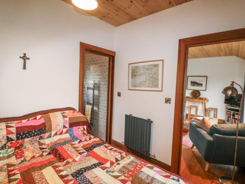 a bedroom with a bed with a quilt on it at Bosca Neadu in Dingle