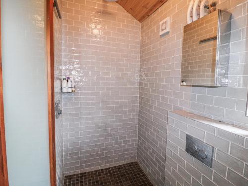 a bathroom with a shower with gray tiles at Bosca Neadu in Dingle