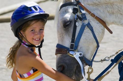 a young girl is standing next to a horse at La Palma Polo Hotel - Airport Area in Puembo