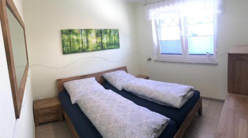 two beds in a small room with a window at Kompassrose in Prerow