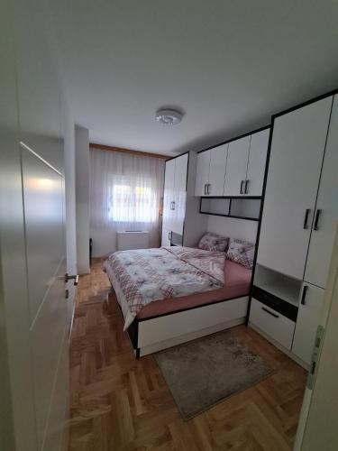 a bedroom with a bed and white cabinets at Plavi Safir stan in Bijeljina