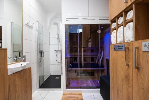 a bathroom with a shower and a glass door at BioKompas SPA Apartment in Wrocław