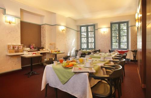 a restaurant with tables and chairs with food on them at Hotel De Gramont in Pau