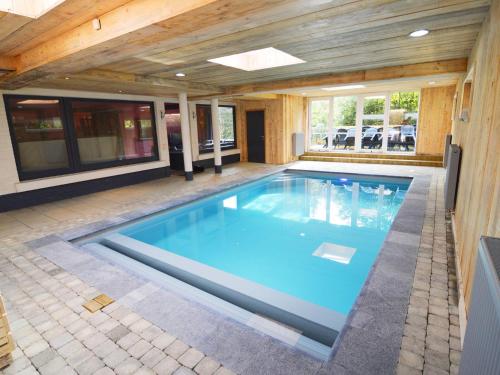 a swimming pool in a house with a wooden ceiling at Appealing holiday home in Malm dy with indoor pool in Malmedy