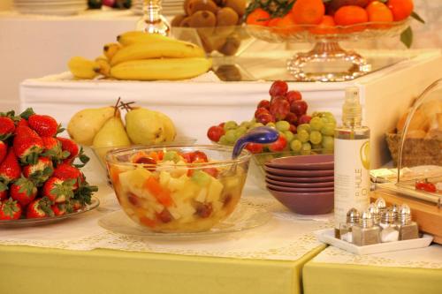 a table topped with bowls of fruit and plates of food at Hotel De Gramont in Pau