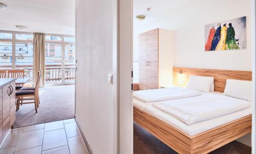 a bedroom with a bed and a dining room at Grafenberg Resort by Alpeffect Hotels in Wagrain