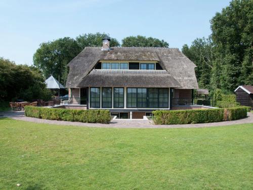 a large house with a thatched roof at Mansion in Nijensleek with Sauna & Garden in Nijensleek