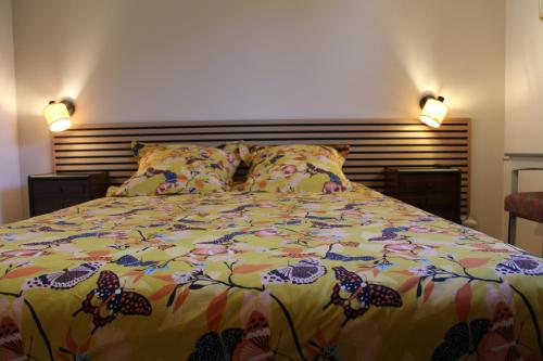 a bedroom with a bed with a colorful comforter at Les 1000 Vignes in Frontignan