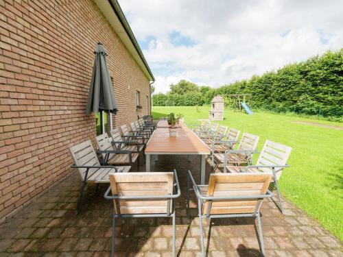 a table with chairs and an umbrella on a patio at Holiday home in Waimes Robertville with sauna in Waimes